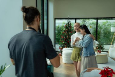 Modern bir oturma odasında ifade edici bir yüzü olan genç bir kızı kucaklayan bir kadın.