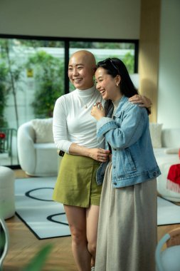 İki gülümseyen kadın, mutluluğu ve arkadaşlığı parlak bir yaşam alanında paylaşıyorlar.