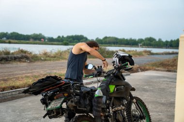 Adam park ettiği macerada vites ayarlıyor. Sakin bir vücutla motosiklet turu yapıyor.