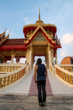 Merdivenlerin başında dikilen adam canlı bir Thai tapınağına gidiyor.