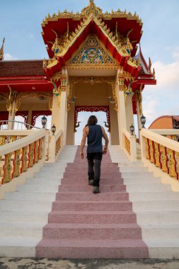 Gezgin, canlı bir Budist tapınağı girişine doğru büyük bir merdiven çıkıyor.