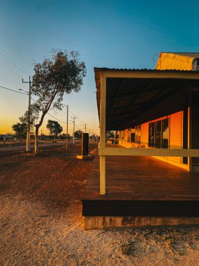 Gün batımında kırsal ahşap verandalı Avustralya mimarisi sergilenen taşra binası.