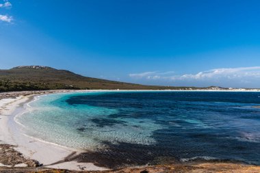 Lucky Körfezi 'nde turkuaz su buluşması açık mavi gökyüzünün altında el değmemiş beyaz kumsal sahili var.
