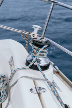 Vinç, okyanusta yelken açarken güvertede ipi kontrol eder.