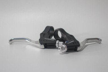 Beyaz zemin üzerinde izole bisiklet fren kolları, metal ve plastik bisiklet bileşenleri yol bisikleti ve dağ bisikleti, mekanik fren sistemi detayı.