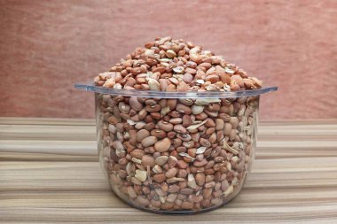 Şeffaf bir kâse içinde kahverengi organik fasulye yığını. Yapısını, şeklini ve büyüklüğünü gösteriyor.