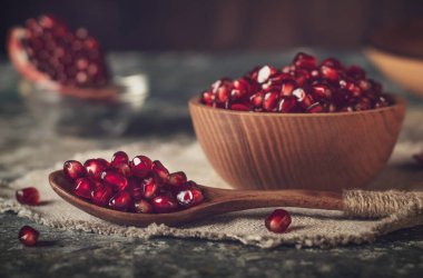 Ahşap kaşık ve tabak keten kumaş üzerinde nar tohumları