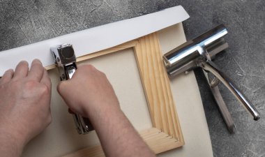 Tabloyu sedye çerçevesine germe işlemi.