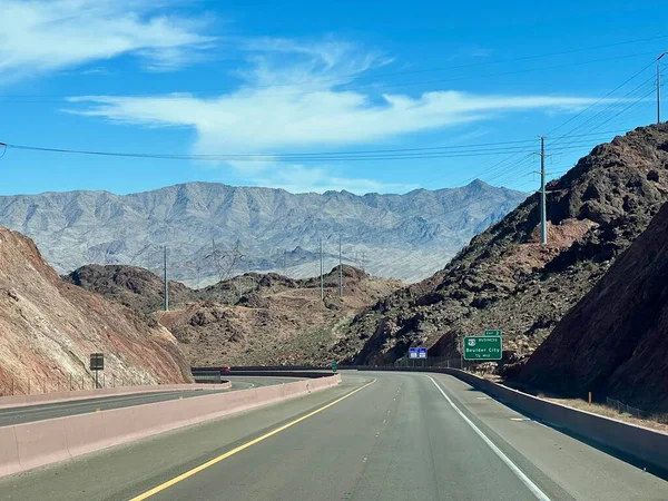 Yol boyunca dağ manzarası. Bu resim, daha az tepenin eteğindeki modern çok şeritli bir yolu gösteriyor. Açık gün ışığı manzaranın ölçeğini vurgular.
