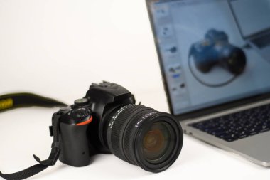 Prodüksiyon ve montaj için DSLR kamera ve laptop ile profesyonel fotoğrafçılık. Yaratıcı iş temaları için kopyalama alanı olan temiz beyaz arkaplan.