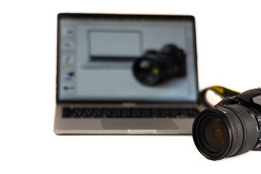 Fotoğrafçılık iş akışı konsepti: ön planda lens ve arka planda fotoğraf düzenleme arayüzü olan dizüstü bilgisayar. İçerik oluşturma, post-prodüksiyon ve kopyalama alanı için mükemmel.