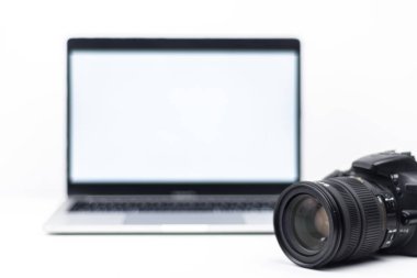 DSLR lensleri ve boş ekranlı dizüstü bilgisayarı olan en az gelişmiş sahne. Fotoğraf işi için kavram, kopyalama alanı ile iş akışı ve teknoloji düzenleme.