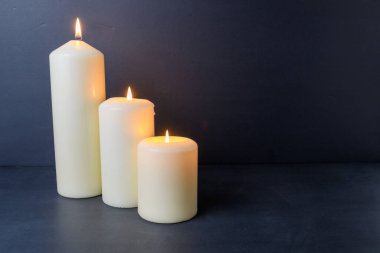 Koyu arkaplanda parlak sütun mumları ve tasarım için sıcak parıltı ve kopyalama alanı.