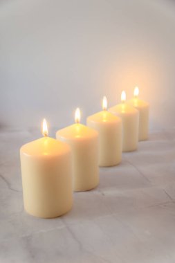 Yumuşak ışık, gece nöbeti ve anma konseptiyle mermer yüzeyde beş mum, kutsal hafta ve maneviyat, kopyalama alanı.