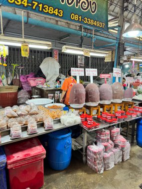 Geleneksel Tayland pazarında kapalı pazar yapısı altında korunmuş gıda, sos ve malzemeler sergileniyor.