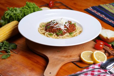 Domates soslu makarna ve rendelenmiş peynir, geniş kenarlı tabakta servis edilir..