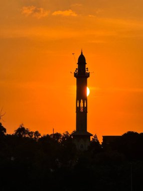 Rawang, Selangor, Malezya - 26 Ocak 2026: Bir caminin silueti turuncu bir gün batımı gökyüzüne karşı, inancı, sakinliği ve ruhani yansımayı simgeliyor..