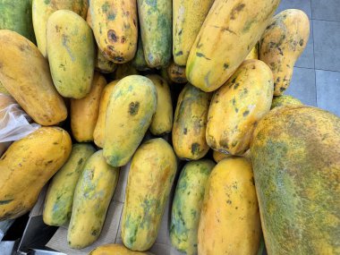 Meyve tezgahında olgun papayalar, vitamin ve doğal tatlılık açısından zengin tropikal meyveler..