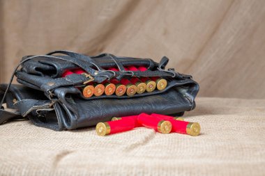 Arka planda kırmızı kartuşlar olan Hunter 'ın deri çantası.