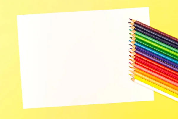 Multi-colored pencils on a yellow background. Top view. Copy space. — Stock Photo, Image