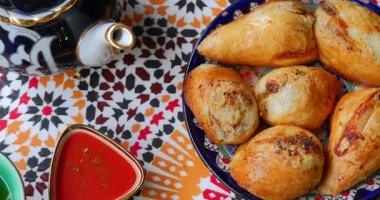 Özbek samsa renkli geleneksel masada sos ve çayla servis edilir. Yüksek kalite 4k görüntü