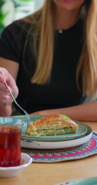 Kadın, doğu kahvesinde çayla birlikte fıstıklı baklava yemeye hazırlanıyor. Yüksek kalite 4k görüntü
