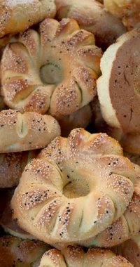 Susam ve haşhaş tohumlu taze pişmiş geleneksel Özbek ekmeği. Yüksek dikey 4k görüntü