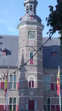 Güneşli bir günde tarihi bir Avrupa şehrinde Carillon saat kulesi olan eski tuğla bina