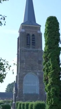 Avrupa 'nın tuhaf bir kasabasında çan kulesi ile çevrili tarihi tuğla kilise kulesi.