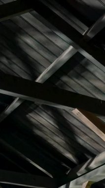 Hareket eden gölgeler gizemli ve ürkütücü bir atmosfer yaratıyor. Geceleri ahşap çatı yapısında.