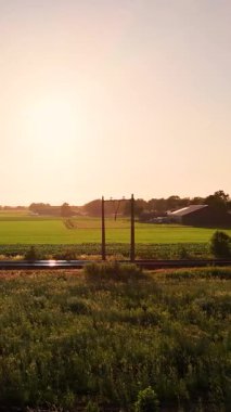 İki katlı trenler güzel bir günbatımında kırsal bir arazide seyahat ediyorlar.
