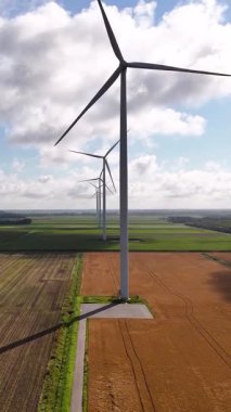 Birden fazla rüzgar türbini temiz ve yenilenebilir enerji üretmek için tarımsal alanların üzerinde yavaşça dönüyor