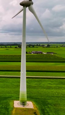 Bereketli yeşil tarım alanları üzerinde temiz ve yenilenebilir enerji üreten rüzgar türbini