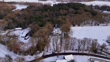 Yoğun Woodland ve viraj yollarıyla çevrili Karla kaplı Köy ve Mülk Gündoğumu Rooflines