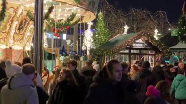 Atlıkarınca Işıkları Hareketli Bölgede, Biniciler Gülüyor, Kırmızı Bilet Booth, Yoğun Kalabalık, Köln, Almanya 'da Noel Pazarı' nda 7 Aralık 2025 'te