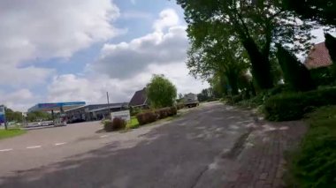 Pov, güzel güneşli bir günde Hollandalı bir köyün kanalında bisiklet sürerken çekildi.