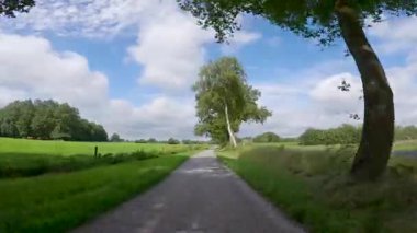 Yeşil bir Hollanda kırsalında bisiklet sürerken ya da dar bir patika boyunca araba sürerken pov çekimi