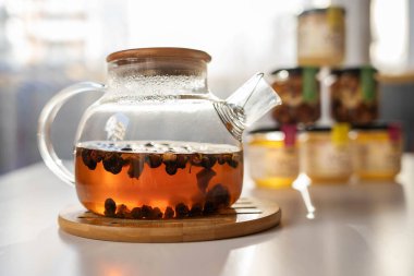 Kavanozların ve fındıkların yanında cam çaydanlıkta sıcak gül suyu çayı.