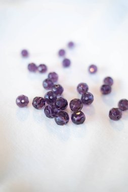 Tasarım projeleri için beyaz kumaş üzerine cetvel takılı klasik mor boncuklar.