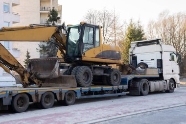 Ağır bir kazıcı kargo platformunda taşınıyor.