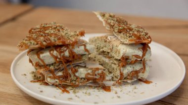 Fıstıklı kunafa dondurması üzerine ezilmiş şam fıstığı, üzerine de tahta bir masada tatlı fotoğrafı, ön manzara..