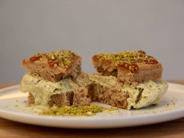 Beyaz bir tabakta ezilmiş şam fıstıklı tatlı dilimleri ahşap bir masada tatlı fotoğrafçılığı, ön manzara..