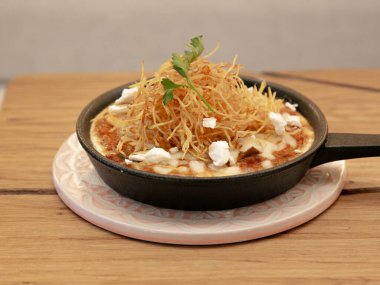 Fırında yumurta, eritilmiş peynir, dökme demir tavada, kahvaltı yemeği fotoğrafçılığı ahşap bir masada, üst görünümde..