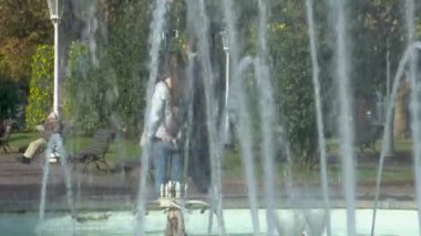 Sonbaharda Bilbao 'daki tarihi Casilda Iturrizar Parkı. Havuza yansıyan güzel bakır ve kırmızımsı ağaçlar. Yerel halk ördeklerin, kazların ve kuğuların yanında yürüyüp dinleniyor. İspanya 'nın Bask ülkesinde barışçıl kentsel doğa sahnesi.