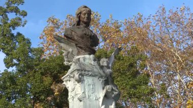 Sonbaharda Bilbao 'daki tarihi Casilda Iturrizar Parkı. Havuza yansıyan güzel bakır ve kırmızımsı ağaçlar. Yerel halk ördeklerin, kazların ve kuğuların yanında yürüyüp dinleniyor. İspanya 'nın Bask ülkesinde barışçıl kentsel doğa sahnesi.