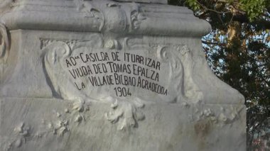 Sonbaharda Bilbao 'daki tarihi Casilda Iturrizar Parkı. Havuza yansıyan güzel bakır ve kırmızımsı ağaçlar. Yerel halk ördeklerin, kazların ve kuğuların yanında yürüyüp dinleniyor. İspanya 'nın Bask ülkesinde barışçıl kentsel doğa sahnesi.