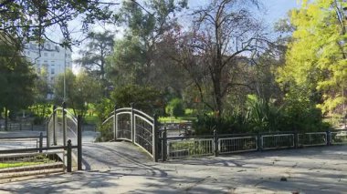 Sonbaharda Bilbao 'daki tarihi Casilda Iturrizar Parkı. Havuza yansıyan güzel bakır ve kırmızımsı ağaçlar. Yerel halk ördeklerin, kazların ve kuğuların yanında yürüyüp dinleniyor. İspanya 'nın Bask ülkesinde barışçıl kentsel doğa sahnesi.