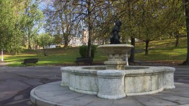 Sonbaharda Bilbao 'daki tarihi Casilda Iturrizar Parkı. Havuza yansıyan güzel bakır ve kırmızımsı ağaçlar. Yerel halk ördeklerin, kazların ve kuğuların yanında yürüyüp dinleniyor. İspanya 'nın Bask ülkesinde barışçıl kentsel doğa sahnesi.