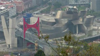 Artxanda Dağı 'ndan Bilbao' nun panoramik görüntüsü, La Salve Köprüsü, Guggenheim Müzesi ve çevre şehir binaları sergilenmektedir. Şehirler, modern mimari ve kentsel manzara hakkında net bir bakış açısı.