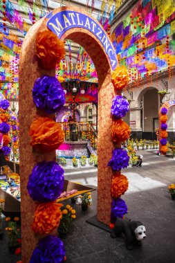 Meksika 'da Ölüler Günü' nde sunaklar, adaklar ve madalyalar. Merhumu onurlandıran unsurlardan oluşan bir derleme. İspanyol ve Katolik geleneklerini birleştirip yaşayanlarla ölülerin bir arada olduğu bir festival alanı yaratıyorlar..